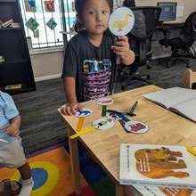 Young girl holding up a yellow duck card