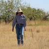 Photo of scientist walking in grassland